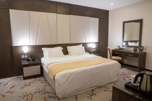 a hotel room with a large bed and a mirror at Ayan Hotel in Riyadh