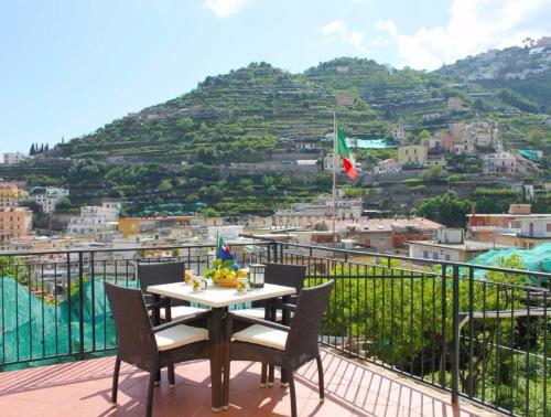 a table and chairs on a balcony with a mountain at Eden Holiday in Minori