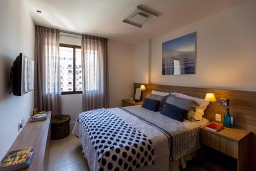 Dormitorio con cama, escritorio y TV en Leblon Inn, bonito apartamento, en Río de Janeiro
