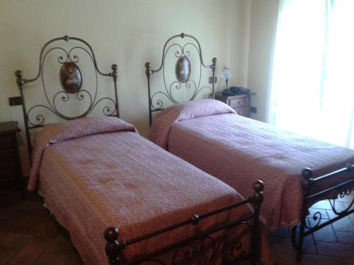 two beds sitting next to each other in a bedroom at Agriturismo La Sapienza in Monestirolo