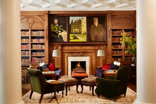 a library with a fireplace and bookshelves at Rusacks St Andrews in St Andrews