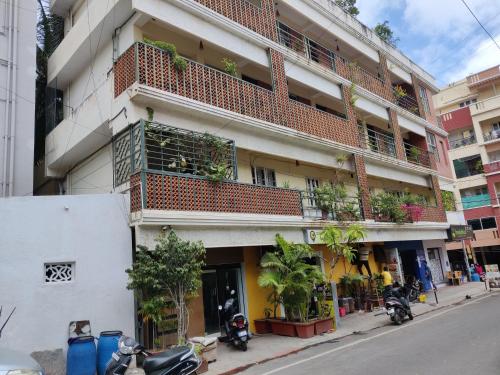 un edificio de apartamentos con un balcón con plantas. en Fernandes Complex, en Bangalore