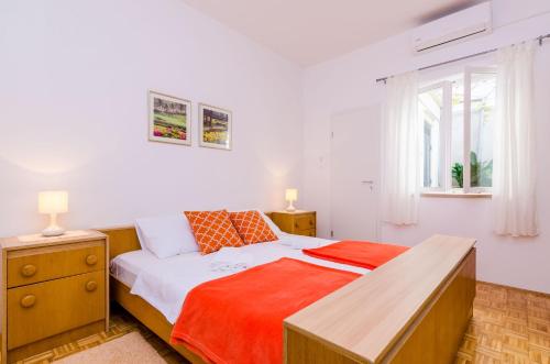 Un dormitorio con una cama y un escritorio y una ventana. en Rooms Batina, en Dubrovnik