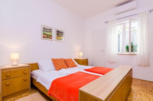 a bedroom with a bed and a desk and a window at Rooms Batina in Dubrovnik