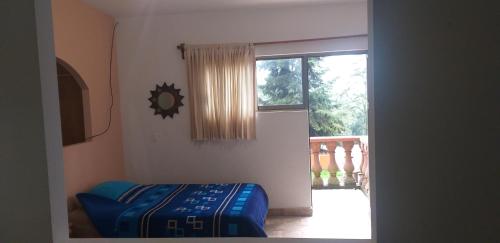 a room with a blue ottoman in front of a window at Hotel Villas Monteli Suites Cuernavaca in Cuernavaca