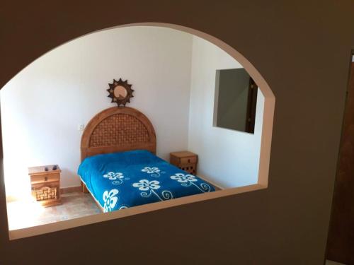 a bedroom with a bed with blue sheets and an archway at Hotel Villas Monteli Suites Cuernavaca in Cuernavaca