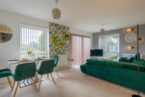 a living room with a green couch and a table at LillyRose Apartments - Hemel Hempstead, Free Parking, Free Wi-Fi in Kings Langley