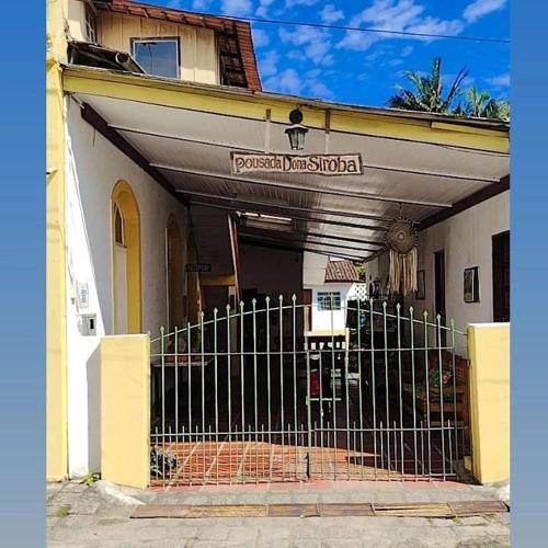 a building with a gate in front of it at Pousada e Restaurante Dona Siroba in Morretes