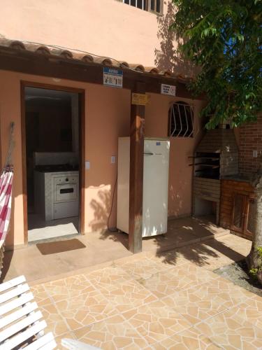 an outdoor kitchen with a refrigerator and a stove at Casa com piscina e churrasqueira em Iguaba grande in Iguaba Grande