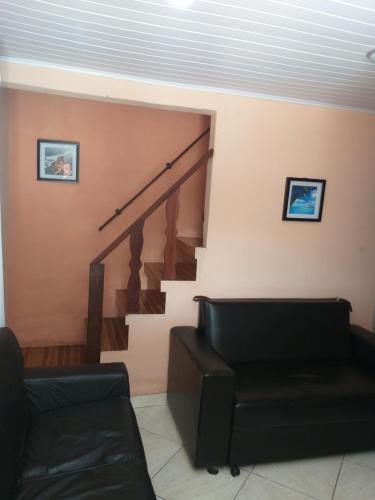 a living room with a staircase and a couch at Casa com piscina e churrasqueira em Iguaba grande in Iguaba Grande