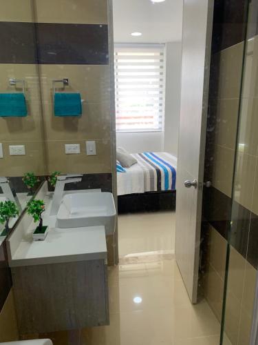 een badkamer met een wastafel en een bed in een kamer bij APARTAMENTO Samaria Pozos Colorados 6per 2Hb Santa Marta in Santa Marta