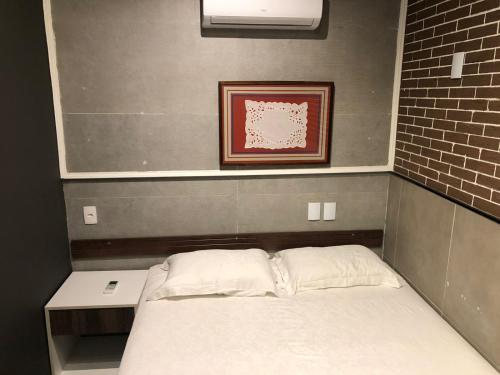 a bed in a room with a picture on the wall at iHOSTEL ALDEOTA in Fortaleza