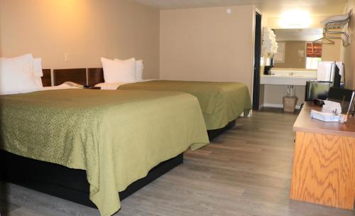 a hotel room with two beds and a television at Ranch Motel in Salem