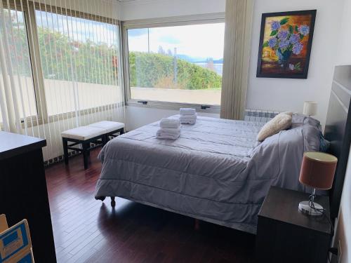 1 dormitorio con cama y ventana grande en - QUINTA LUNA - Depto 4 personas en San Carlos de Bariloche