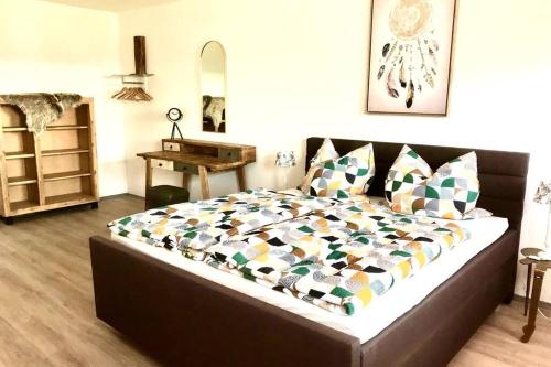a bedroom with a large bed with pillows and a table at Classik Western Apartment Rusty in Eging