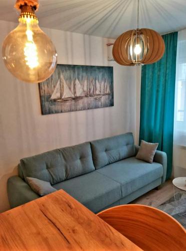 a living room with a blue couch and a table at PREMIUM APARTMAN JAGODINA in Jagodina