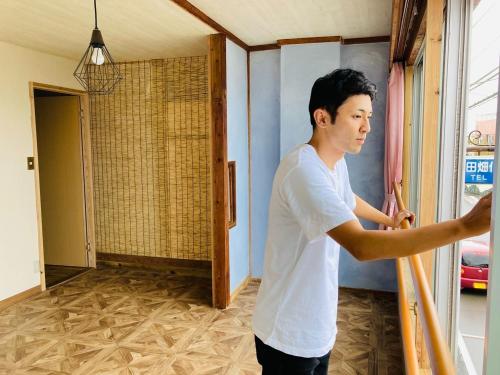 a man is painting a wall in a room at Challenge kyoten YOKANA - Vacation STAY 63919v in Noma