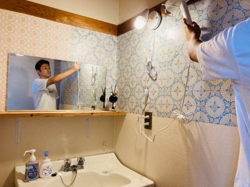 a man is taking a picture in a bathroom mirror at Challenge kyoten YOKANA - Vacation STAY 63919v in Noma