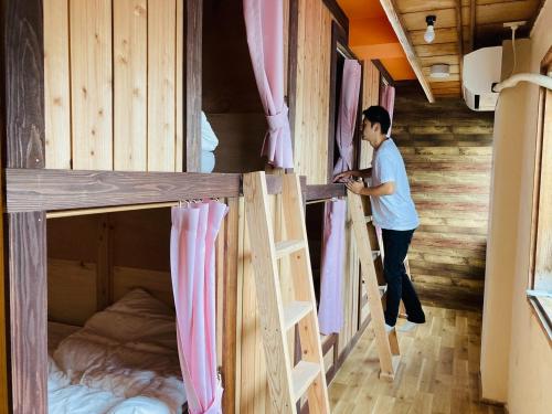 a man standing in front of two bunk beds at Challenge kyoten YOKANA - Vacation STAY 63968v in Noma