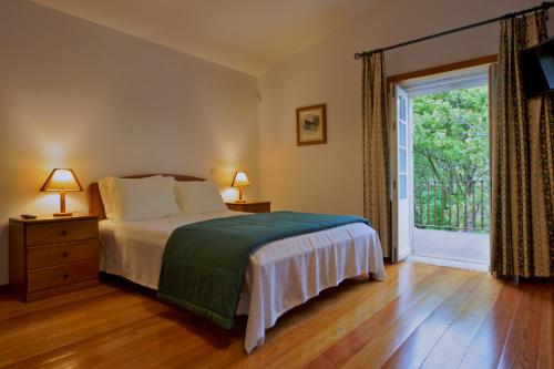 a bedroom with a bed and a large window at Casa da Aldeia in Sever do Vouga