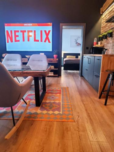 ein Wohnzimmer mit einem Netflix-Schild an der Wand in der Unterkunft Casa Larisa Apartments in Sinaia
