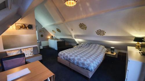 a bedroom with a bed and a desk and a table at Logeren op Dijk43 in Broek op Langedijk