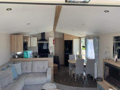 uma sala de estar e cozinha com um sofá e uma mesa em 6 Swan View Haven, Littlesea em Weymouth