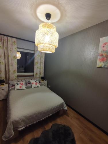 sypialnia z łóżkiem i żyrandolem w obiekcie LUX Apartament ODKRYJ - BIESZCZADY w mieście Ustrzyki Dolne