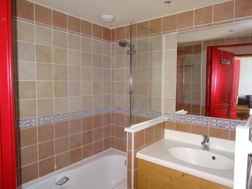 a bathroom with a tub and a sink and a mirror at Les Alpages location appartement 202 in Lanslebourg-Mont-Cenis