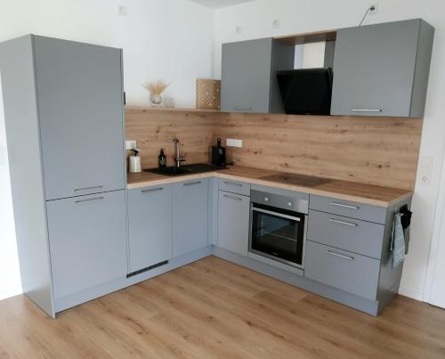 a kitchen with white cabinets and a wooden counter top at Urlaub mitten in Markelsheim in Bad Mergentheim