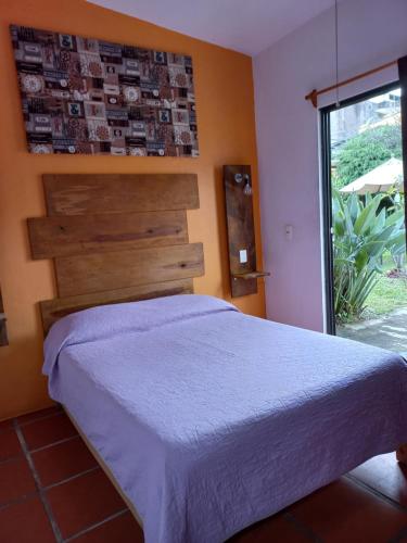 a bedroom with a bed and a large window at Posada Casa Topiltzin in Tepoztlán