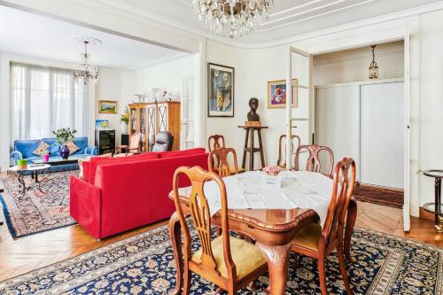 un salon avec une table et un canapé rouge dans l'établissement Appartement Carpette - Welkeys, à Paris