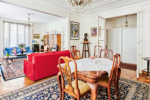 a living room with a table and a red couch at Superb flat two steps away from Porte Maillot in Paris - Welkeys in Paris