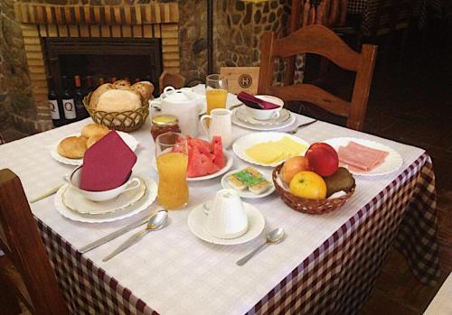 una mesa con platos de comida y fruta. en Casa De Campo Cantinho Da Serra, en Cortelha