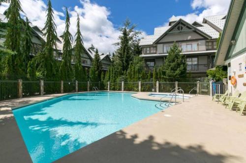a swimming pool in front of a house at Updated Townhouse in Village. Pool/Hot Tub/Parking in Whistler