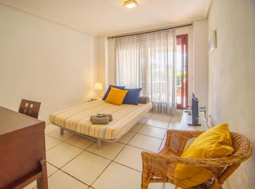 ein Schlafzimmer mit einem Bett, einem Stuhl und einem Fenster in der Unterkunft Mediterranea tus momentos junto al mar (2) in Vera