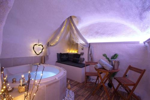 ein Bad mit einer Badewanne und ein Zimmer mit einem Fenster in der Unterkunft Les Secrets d'Alcôve, nuits Romantiques avec SPA in Aix-en-Provence