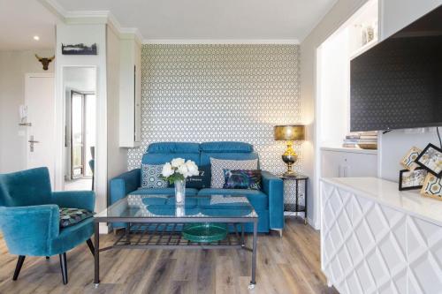 - un salon avec un canapé bleu et une table dans l'établissement Flat with terrace and incredible view in Biarritz - Welkeys, à Biarritz