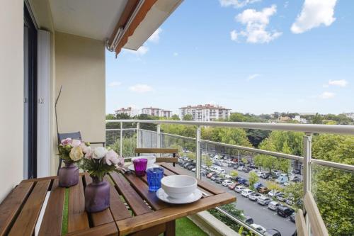 Elle comprend un balcon avec une table en bois et des fleurs. dans l'établissement Flat with terrace and incredible view in Biarritz - Welkeys, à Biarritz