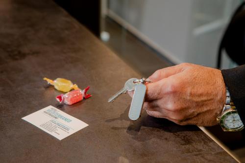 a person holding a pair of scissors on a table at Hotel Mediterraneo in Martinsicuro