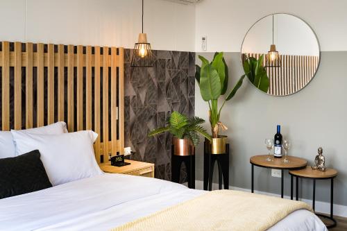 una camera da letto con un letto, due tavoli e uno specchio di Go Living and Suites - Jalo Rent a Medellín