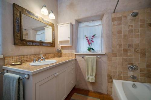 Casa Buena Suerte- Near Plaza- Quiet- Patio- 2 BR في سانتا فيه: حمام مع حوض ومرآة وحوض استحمام