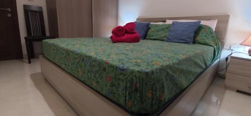 a bedroom with a bed with a green comforter at One Bed Room Apartment with terrace in Marsaskala