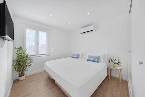 biała sypialnia z dużym białym łóżkiem i oknem w obiekcie Apartamento tranquilo a 500m de la playa w mieście Punta Grossa