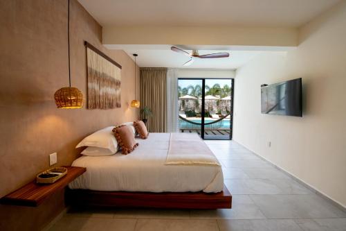 a bedroom with a bed and a view of a pool at Casa Bicachi - Adults Only in Puerto Escondido