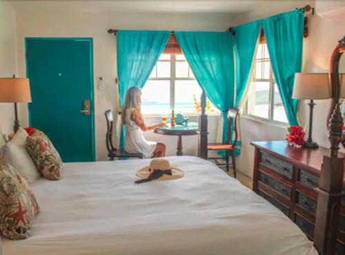 a woman sitting on a bed with a hat on it at The Mafolie Hotel in Mafolie