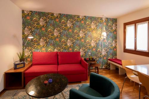 a living room with a red couch and floral wallpaper at Ca' della Scimmia - Rialto Bridge, Venice in Venice