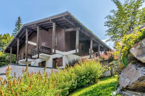 an exterior view of a house with a garden at Appartement des Cerisiers - Welkeys in Megève