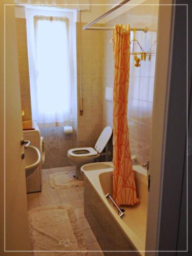a bathroom with a tub and a toilet and a shower curtain at La casa di Palma in Alassio