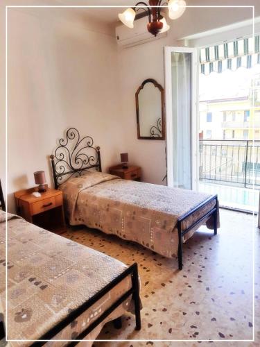 a bedroom with two beds and a large window at La casa di Palma in Alassio